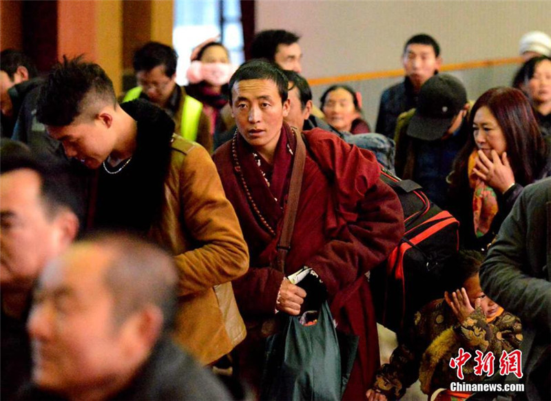 2月4日，一名僧人在拉萨火车站候车厅排队走向火车。李林 摄