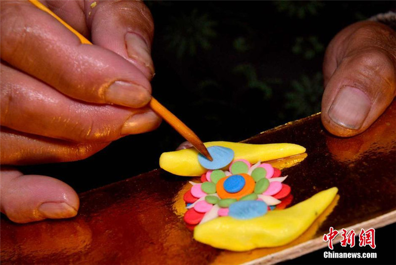 2月7日，艺人正在用木笔刻画酥油花纹路。李林 摄