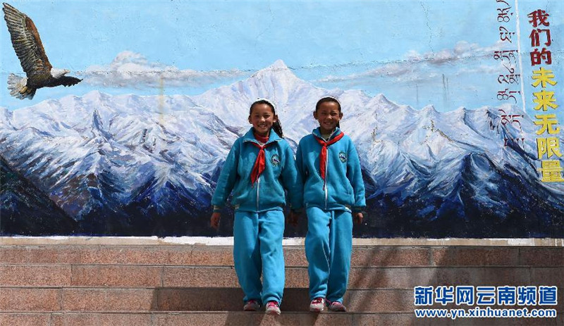 这是双胞胎姐妹此里卓玛（左）和此里央宗站在校园里的宣传画前（3月17日摄）。