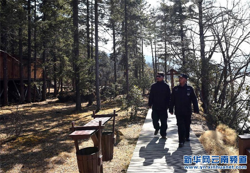 两名工作人员在云南省迪庆藏族自治州香格里拉普达措国家公园里巡逻（3月15日摄）。