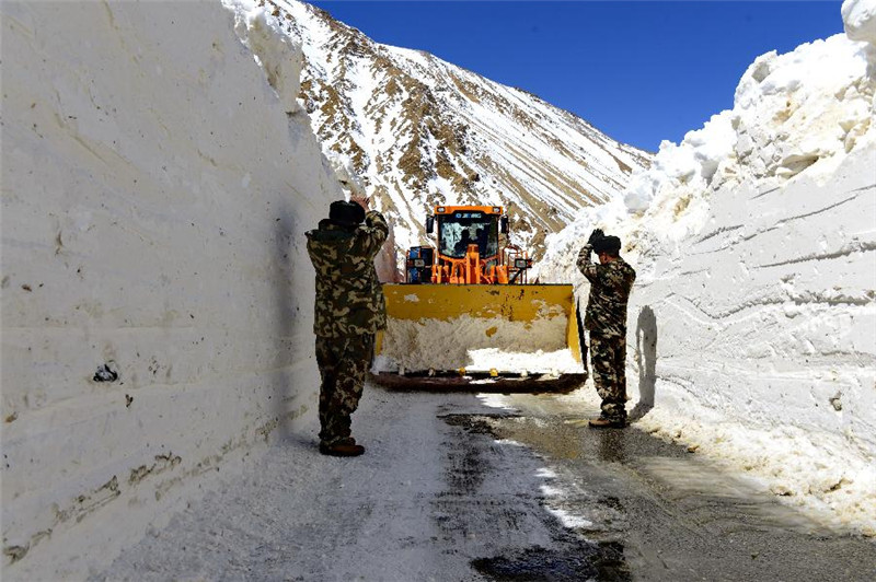 3月20日，武警官兵在厚达3米的积雪路段上进行铲雪作业。
