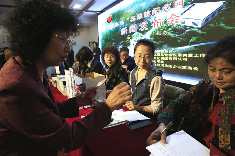 3月31日，爱心人士（左）在西藏察隅”英雄坡纪念园”募捐新闻发布会上捐款。