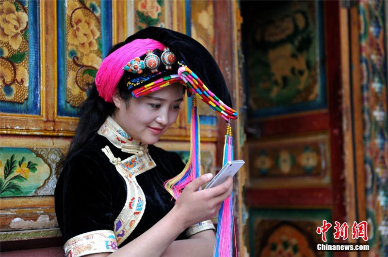 藏寨里玩手机的丹巴女孩。 刘忠俊 摄