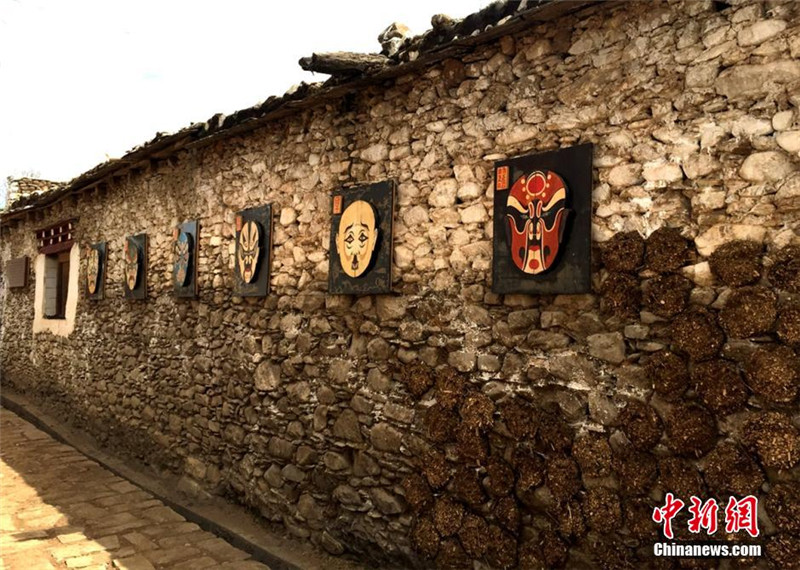道孚县协德乡藏寨里的茶马古道陕西街墙壁上挂着精美的川剧脸谱。 刘忠俊 摄