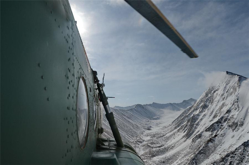 4月21日，新疆军区某陆航旅一架直升飞机正在穿越喜马拉雅山脉的雪山峡谷。