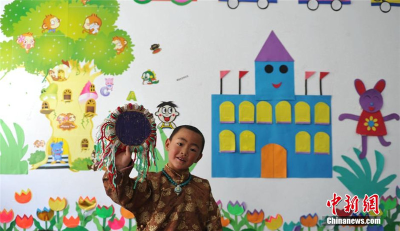 一位教室里一位孩子展示自己的手工作品。刘忠俊 摄