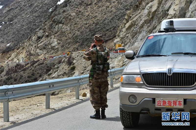 4月26日，在距聂拉木县城5公里处318国道，西藏军区救灾指挥组的一名战士在利用先进设备及时采集传输路况等信息。