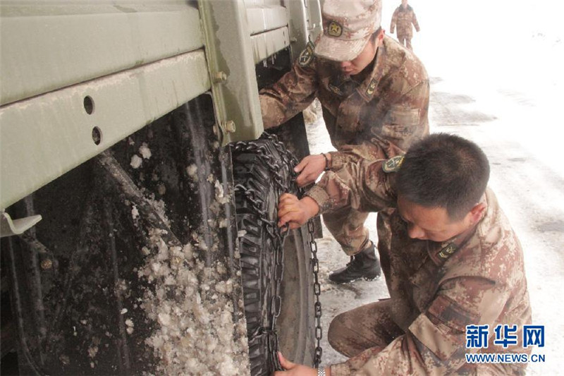 4月26日，驻藏某团战士在给车安装防滑链