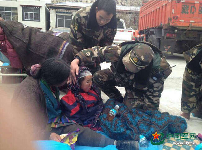图为武警边防派出所官兵救出一名在地震中受伤的8岁孩子。杜皓东 摄