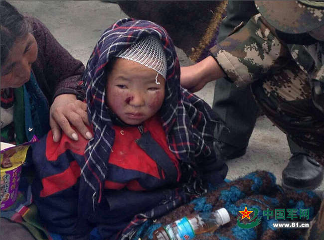 图为武警边防派出所官兵救出一名在地震中受伤的8岁孩子。杜皓东 摄