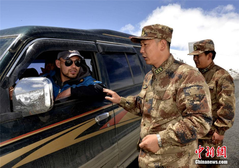 4月26日，西藏军区日喀则军分区副司令员顾炳战询问过往车辆吉隆受灾情况。