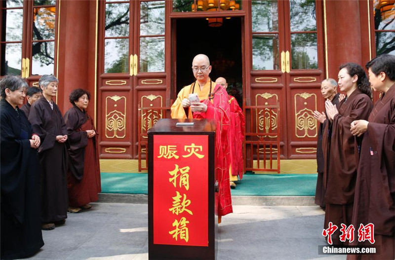 图为中国佛教协会会长学诚法师在法会后捐款。 中新社发 韩海丹 摄