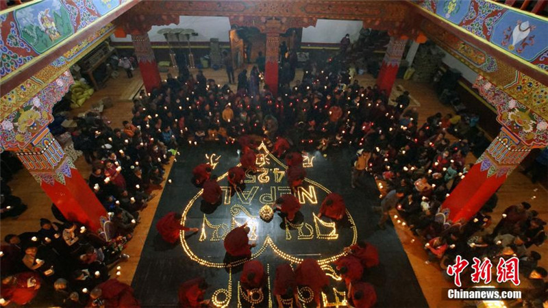 4月28日晚，青海省玉树市民众和僧人在结古寺为尼泊尔地震遇难者点灯祈福。