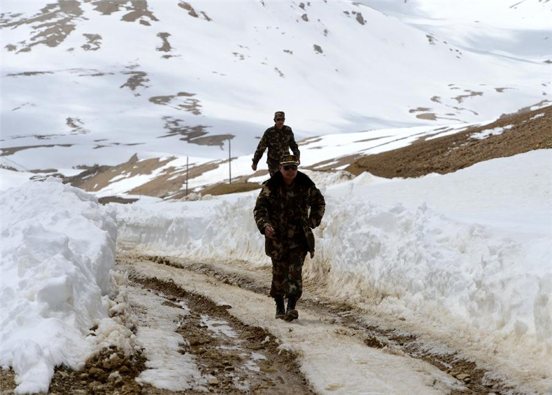 定日县边防武警大队官兵在普孜拉山口查看冰面道路情况（4月28日摄）。
