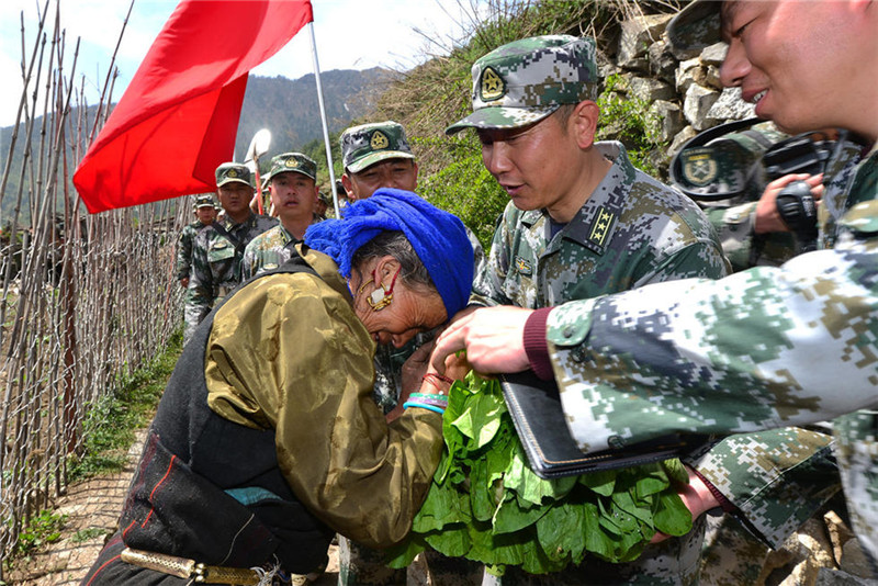 吉甫村67岁的索朗曲珍拦住队伍给军分区领导送上自己种的新鲜蔬菜表示感谢。