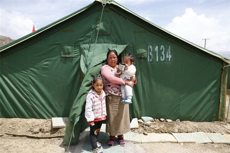 5月7日，普布卓玛与女儿拉巴卓玛（左）、儿子晋美平措在西藏日喀则桑珠孜区安置点自家帐篷前合影。新华社记者 殷刚 摄