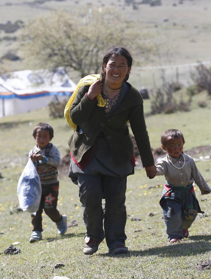 5月9日，西藏日喀则吉隆县乃村的村民在背运领到的救灾物资。