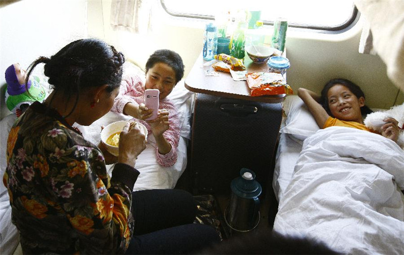 5月12日，11岁的囊嘉卓玛（左）在用手机给正在吃面的妈妈拍照。