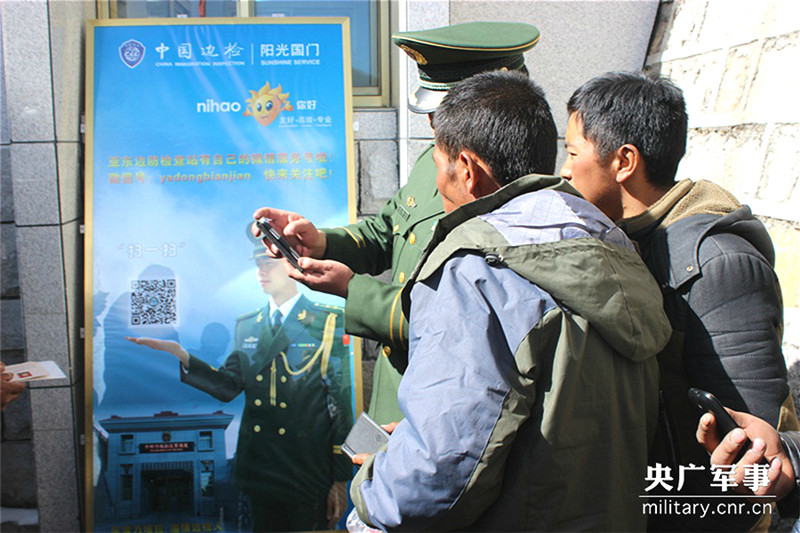 图为亚东边检站官兵正对中方边民讲解亚东边检微信号的使用方法。