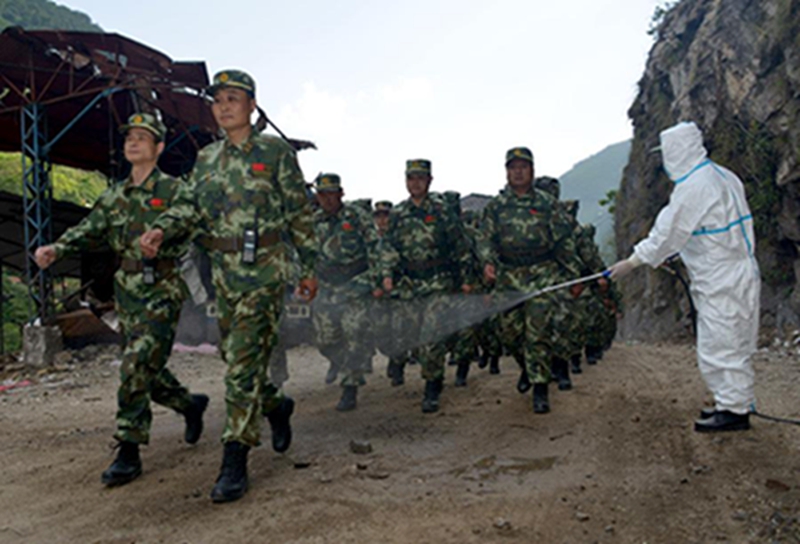5月24日，武警西藏总队医院的医务人员在尼泊尔境内为回国的交通救援大队官兵消毒。