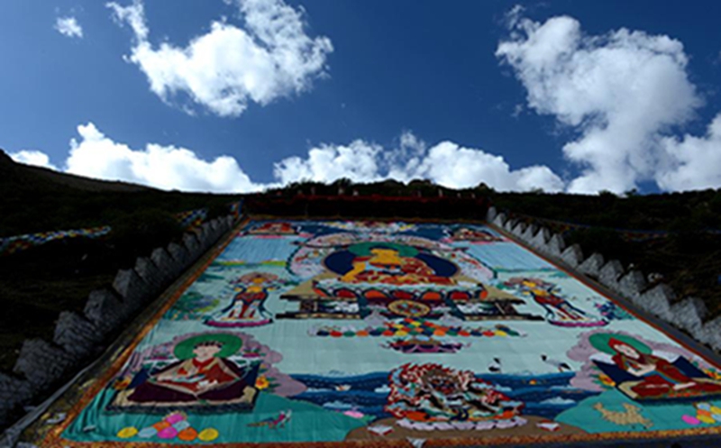 5月29日，在西藏楚布寺，蓝天白云的衬托下的巨幅佛像。