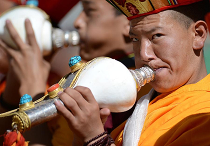5月29日，西藏楚布寺的僧人在展佛仪式上吹海螺。