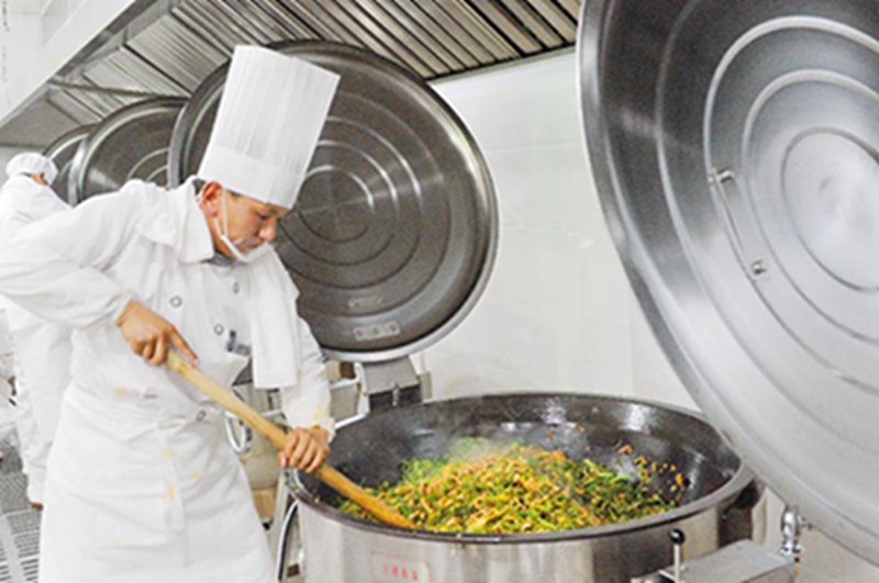 5月29日，拉萨城关区学生午餐配送中心中央厨房的厨师在烹饪菜品。