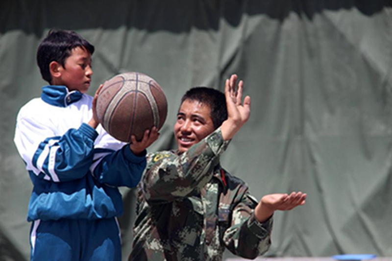 西藏公安边防总队吉隆边防检查站的“边防爸爸”在教结对的“儿子”投篮（5月31日摄）。