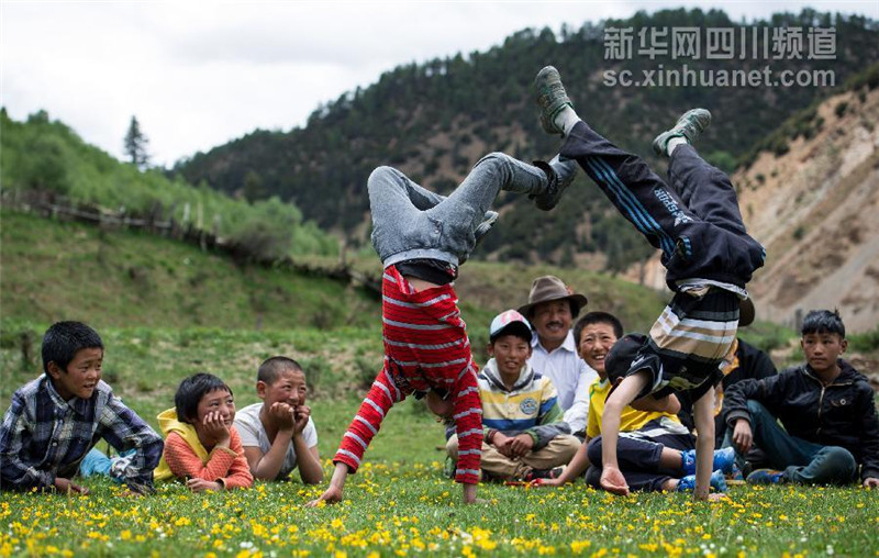 5月31日，雅江县西俄洛乡康巴汉子村，两个孩在玩倒立。
