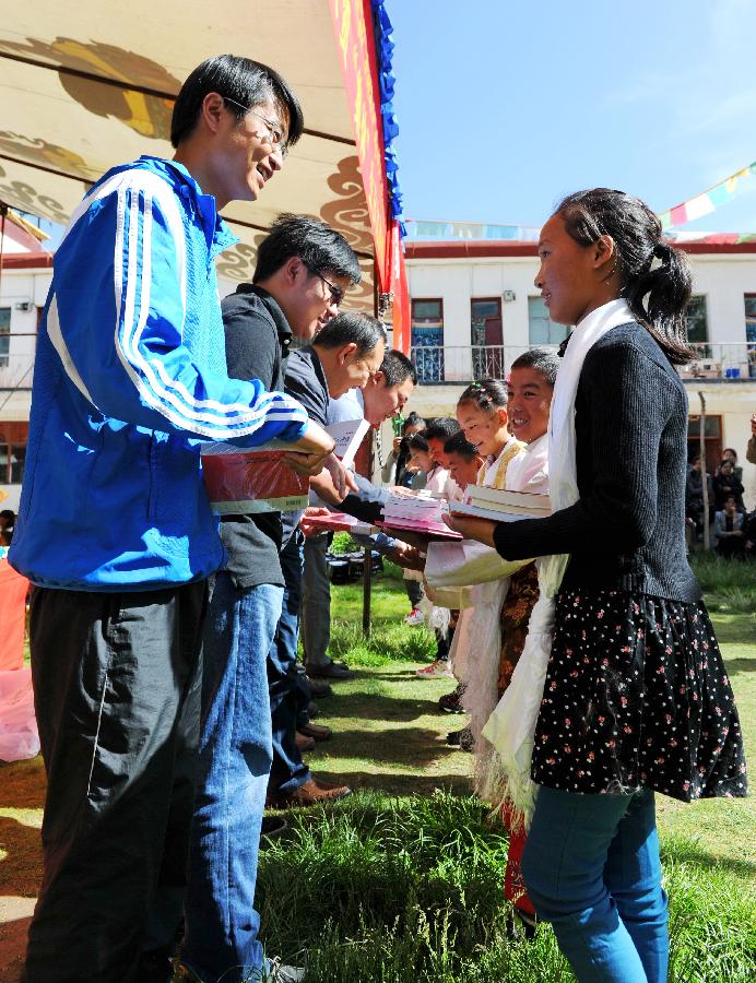 6月6日，援藏干部代表在和拉萨市彩泉公益特殊教育学校的学生互赠礼物。