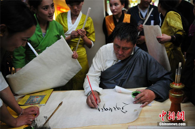 图为众多参观者向藏文书法非遗传承人求字 。唐朝杨 摄