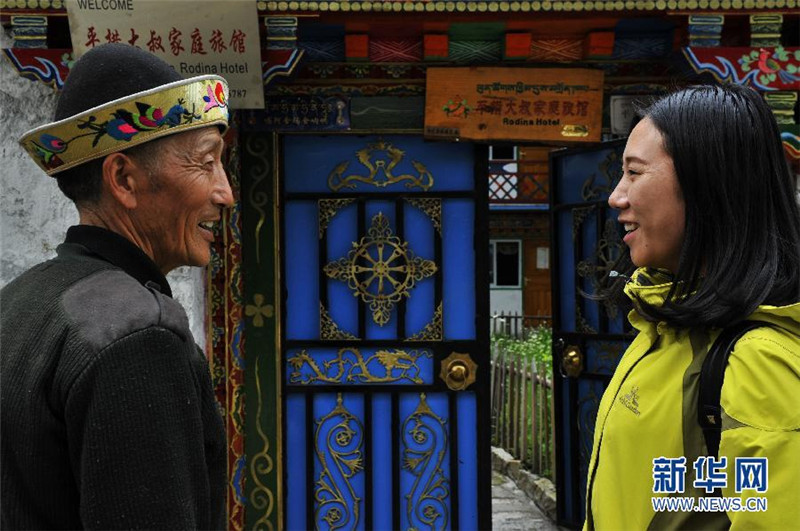 2015年6月15日 平措大叔的家庭旅馆 在西藏林芝扎西岗村，一名游客和“平措大叔”话别（6月11日摄）。