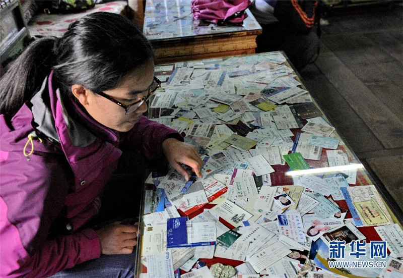2015年6月15日 平措大叔的家庭旅馆一名游客在西藏林芝扎西岗村的平措家庭旅馆阅读以前客人留下的名信片（6月11日摄）。