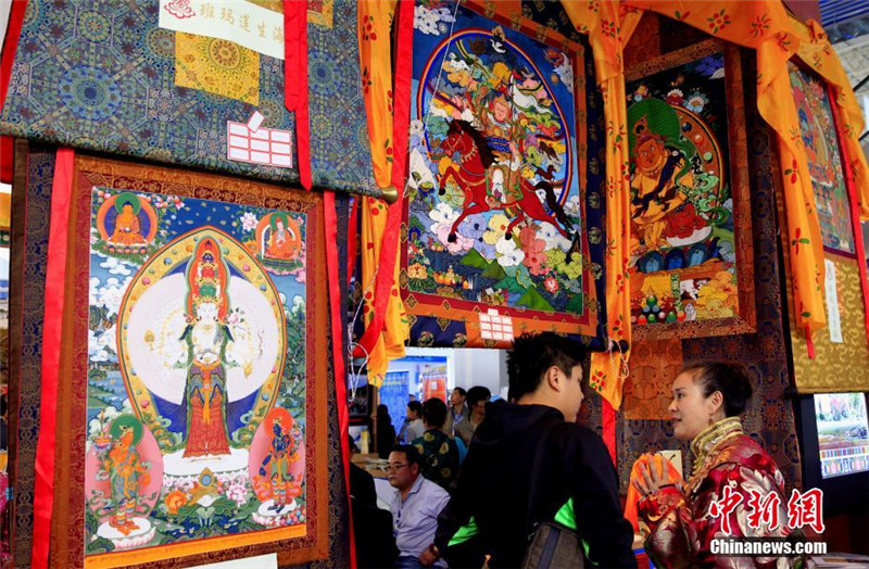 图为一名展商正在了解藏族工艺品制作过程。胡贵龙 摄