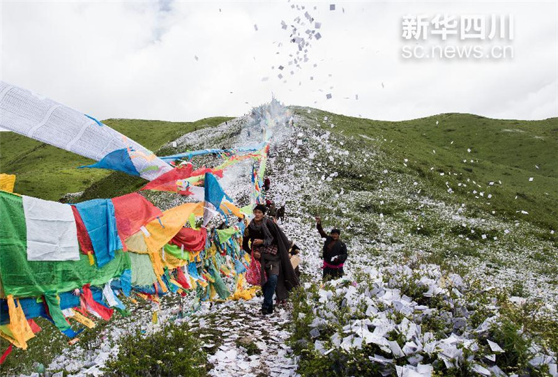 6月23日，四川省红原县藏族群众在煨桑节上抛撒的隆达像雪花一样漫天飞舞。江宏景 摄