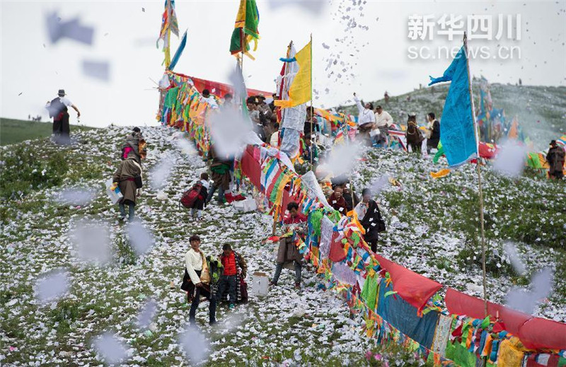 6月23日，四川省红原县藏族群众在煨桑节上抛撒的隆达像雪花一样漫天飞舞。江宏景 摄