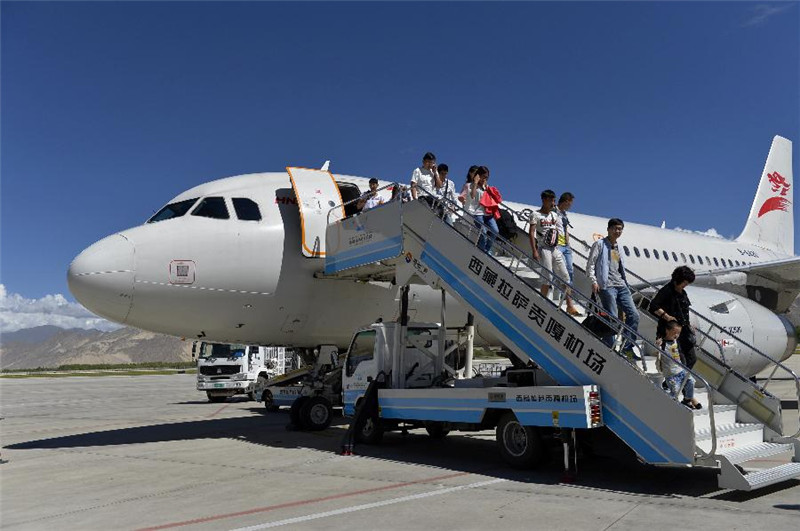 6月30日，旅客从一架抵达西藏拉萨贡嘎机场的航班中走出。