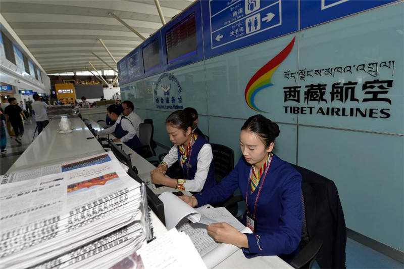 6月30日，西藏拉萨贡嘎机场的工作人员在位于候机大厅中的综合服务台前办公。