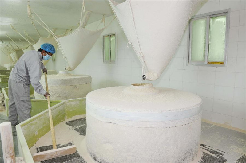一名工人在康桑农产品发展有限公司水磨车间工作（6月30日摄）。