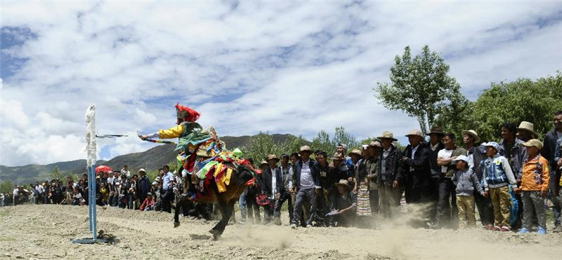 7月14日，藏族群众在“望果节”上进行骑马射箭表演。