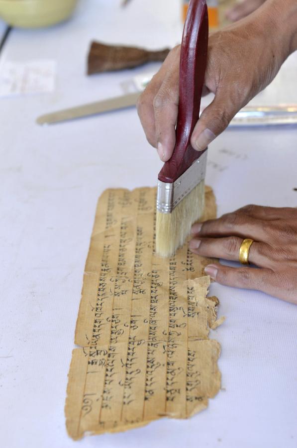 7月22日，西藏古籍修复培训班学员在对破损的藏文古籍文献进行修复。