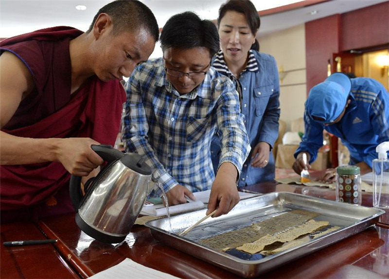 7月22日，西藏古籍修复培训班学员在对破损的藏文古籍文献进行修复。