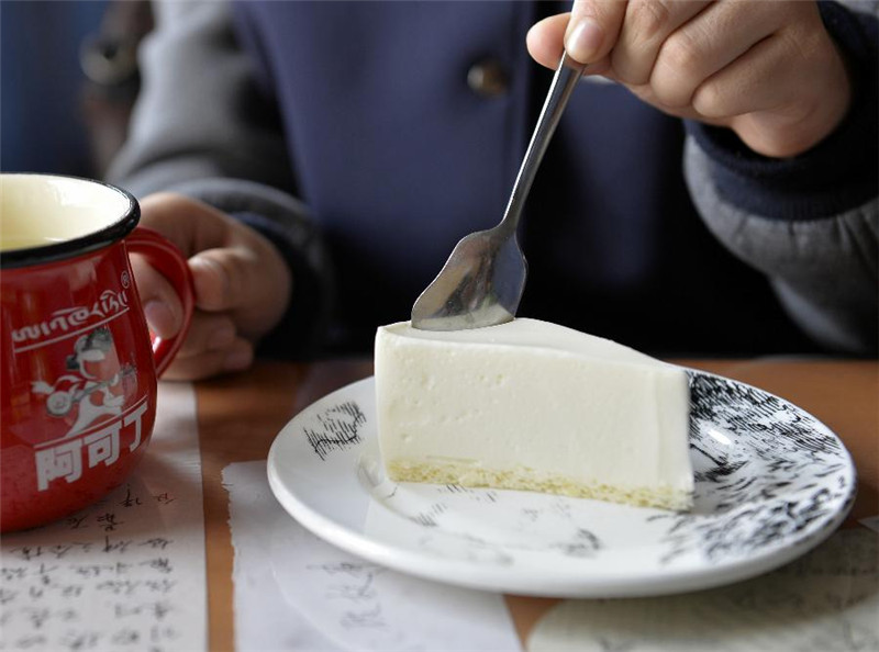 顾客在“阿可丁藏式面包坊”品尝自制酸奶蛋糕（7月9日摄）。