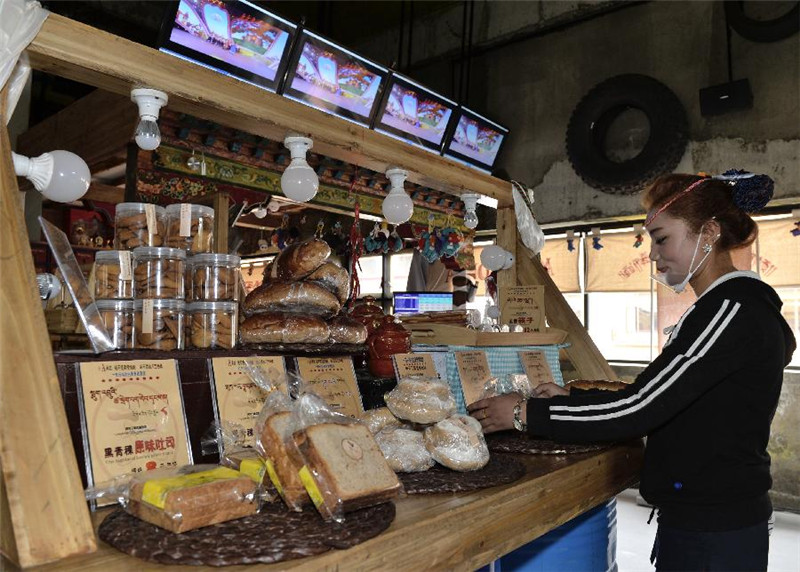 “阿可丁藏式面包坊”的店员在整理柜台上的黑青稞面包（7月9日摄）。