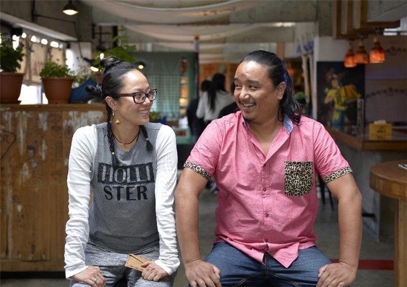“阿可丁藏式面包坊”老板巴桑次仁（右）与妻子满馨蔚在店中合影（7月18日摄）。