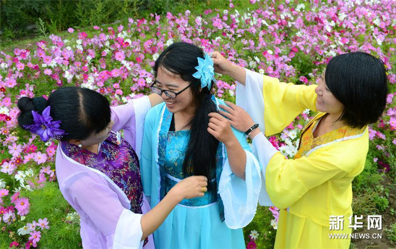8月5日，参加体验活动的游客在花田中扮成“花仙子”。
