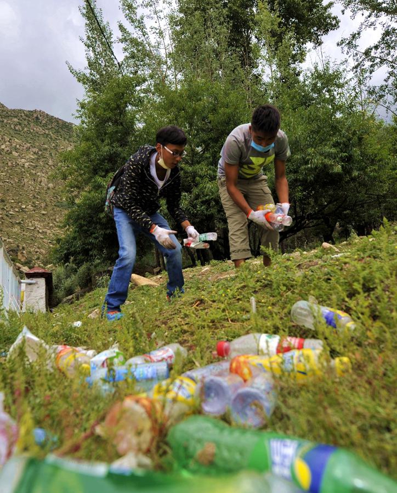 8月17日，环保志愿者在哲蚌寺转经道上捡拾人们丢弃的垃圾。