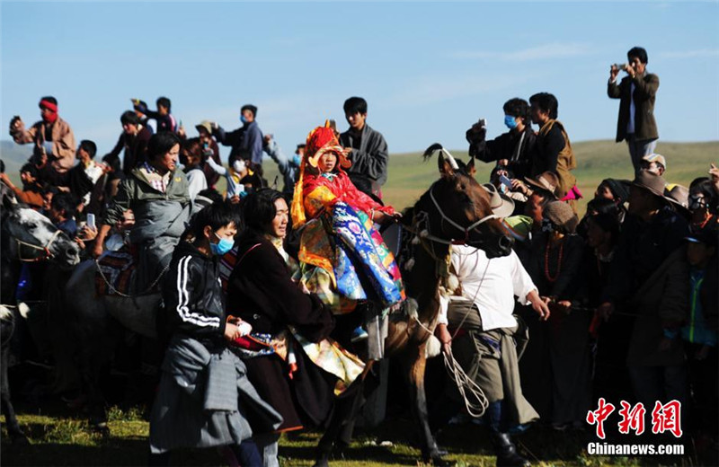 在赛马现场的藏族女牧民。 杨艳敏 摄