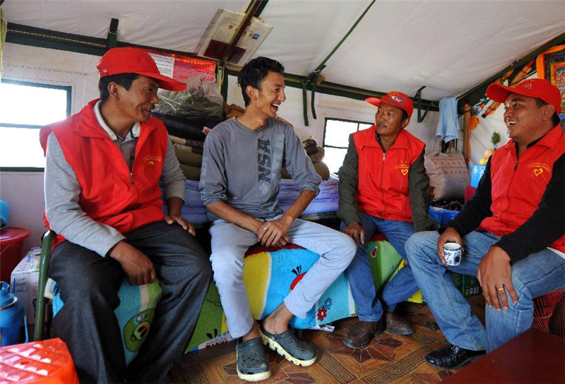 在安置点的帐篷中与地震中受伤的村民聊天（8月25日摄）。