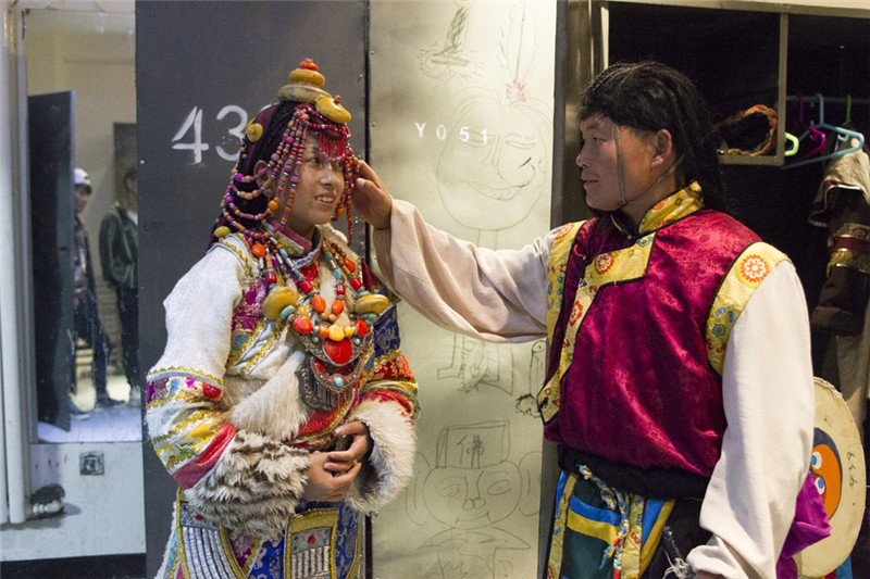 洛旦（右）在演出前为妻子整理服装（8月6日摄）。新华社记者 陈益宸 摄
